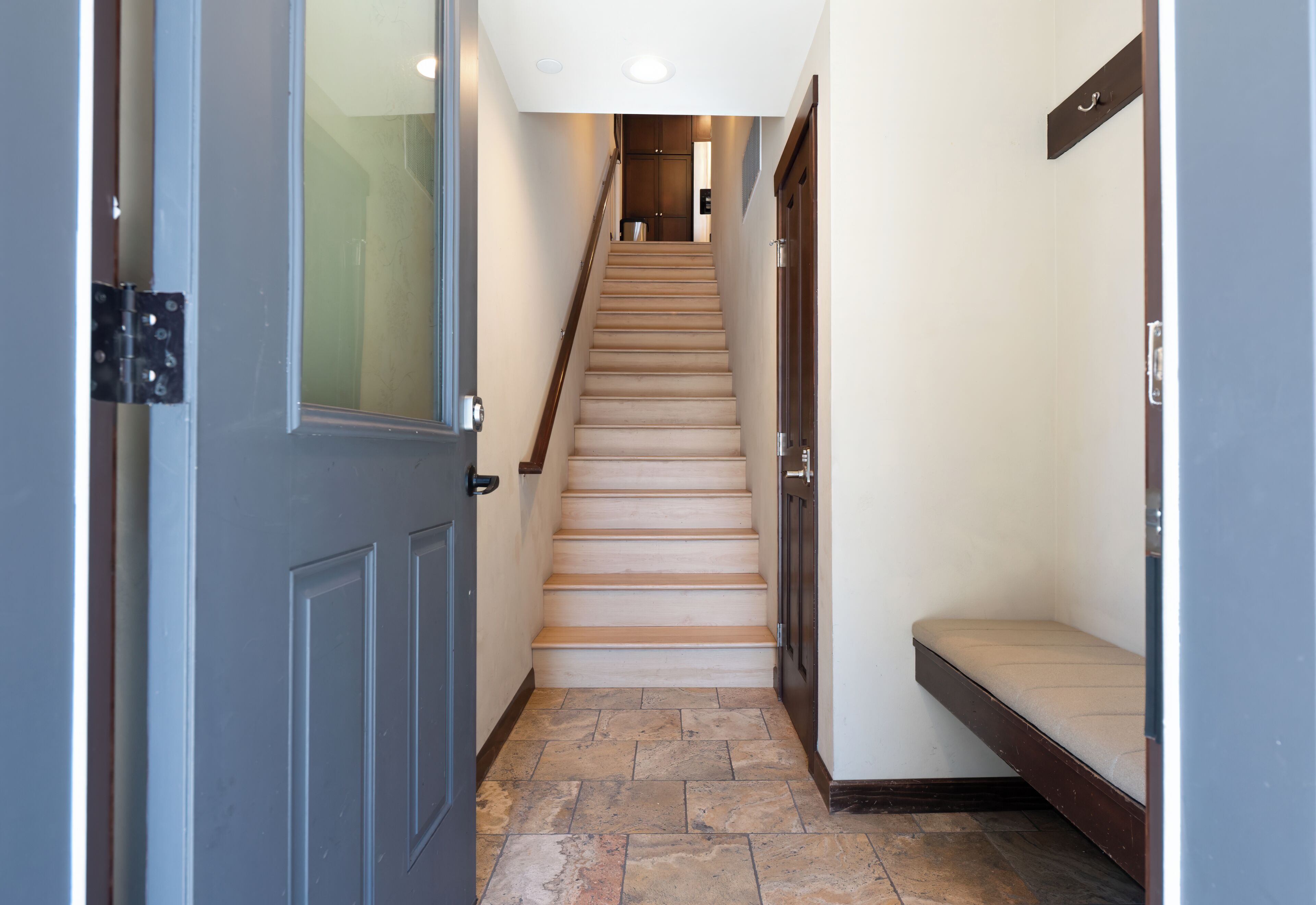 A staircase leading to a landing with a bench.