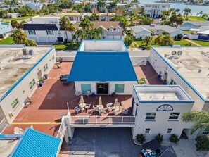 Een hotel met meerdere verdiepingen, een blauw dak, een terras en een zwembad.