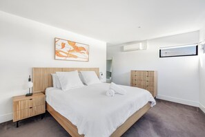 Ein modernes Hotelzimmer mit einem großen Bett, einem Nachttisch, einer Klimaanlage und einem Fenster mit Blick.