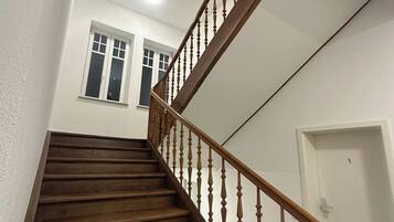 A wooden staircase with a glass balustrade leading to a landing.