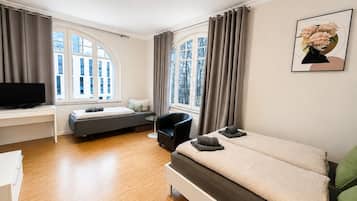Une chambre à coucher moderne, équipée d’un lit, d’un bureau, d’une chaise et d’un téléviseur.