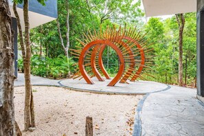 A modern outdoor sculpture in a landscaped garden area. - Luxury 2BR | Private Plunge Pool | Rooftop & Gym (Tulum)