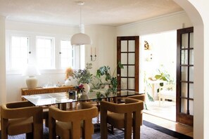 En matplats med ett glasbord och stolar, en lampa och en växt.