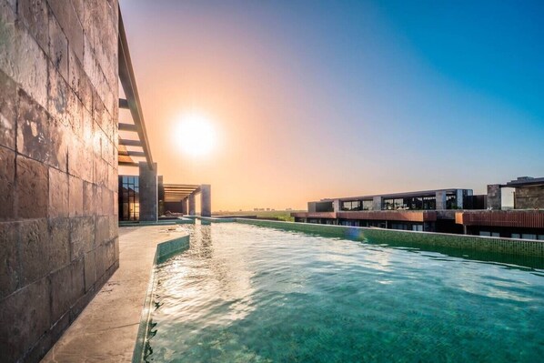 Un bâtiment moderne doté d’une piscine et surplombant un ciel dégagé.