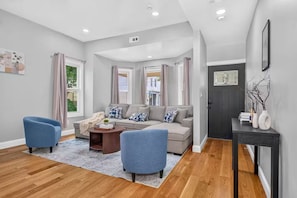 A modern living room with a sofa, two armchairs, a coffee table, and a console table.