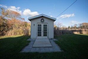 A small, single-story building with a front door and a small porch. - Lake Surround House - Sleeps 11 • Boat Deck • BBQ (Georgina)