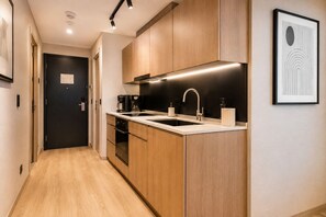 Eine moderne Küche mit Holzausstattung, einer schwarzen Arbeitsplatte und einem Edelstahlspülbecken.