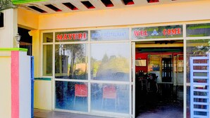 Un restaurant familiar amb un cartell que diu 'MAYURI FAMILY RESTAURANT' i un altre cartell per a 'MAYURI COMECE'.