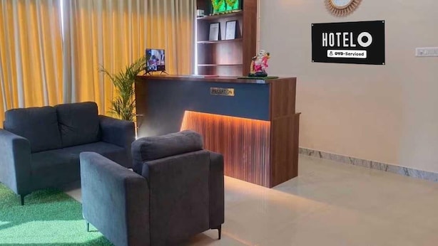 Zona de recepció d'hotel amb taulell de recepció, un sofà i una taula petita.