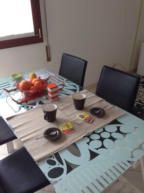 A dining table with chairs, a fruit basket, coffee cups, a bowl, and some packaged snacks. - LA BELLA Flat, Super Easy Venice, Bus stop right in front of Venice (short ride) (Venezia)