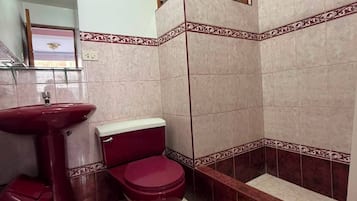 A bathroom with a pedestal sink, a toilet, and a bathtub.