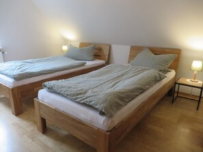 Two wooden beds with matching headboards and nightstands, each with a lamp. - Vrbo Property (Aurich)