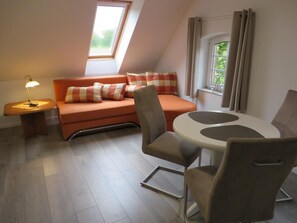 A cozy room with a sofa, a dining table, and a lamp. - NEW! Eisenhower's Cozy Nest (Aurich)