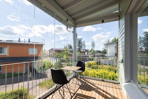 A balcony with a table and chairs, overlooking a residential area with houses and greenery. - Casa Painter - 4BR terraced house with sauna near airport (Vantaa)