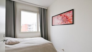Quarto com cama, janela e quadro na parede.