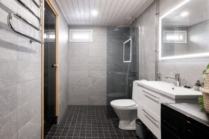 Moderni kylpyhuone, jossa on suihku, wc ja pesuallas.