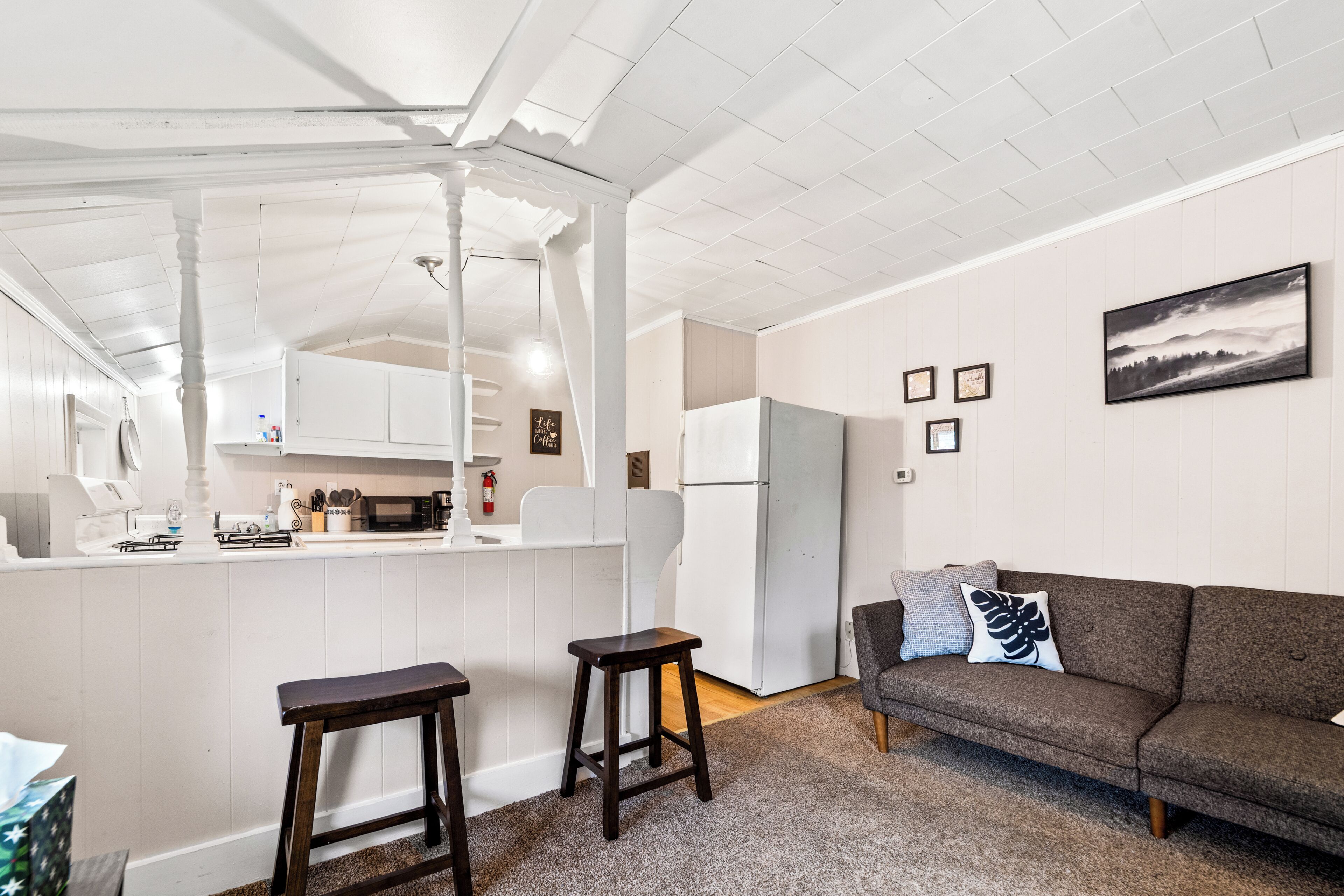 A compact living space with a kitchenette, a sofa, and a dining area.