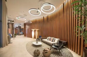 A modern lobby with a sofa, coffee table, and decorative vases. - Breachfront Condo With Oceanview At Lyfe Beach Resort Hollywood Beach (Hollywood)
