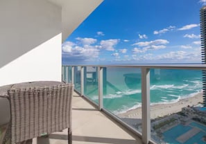 Ein Balkon mit Blick auf den Ozean und den Strand.