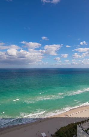 Ein Strand mit klarem türkisblauem Wasser und sandigem Ufer.