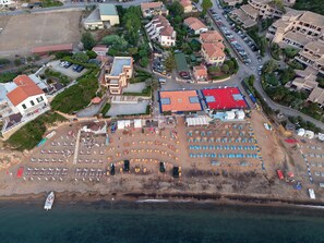 An aerial view of a coastal area with a beach, a sports court, and residential buildings. - Margherita-3 by Appartamenti Margherita seafront accommodation in Giglio Campese (Giglio Campese)