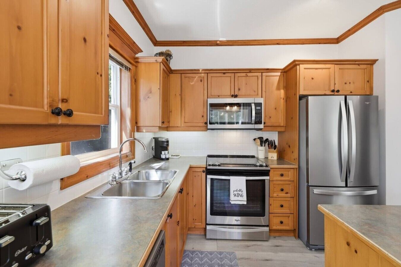 A modern kitchen with wooden cabinets, stainless steel appliances, and a built-in oven.