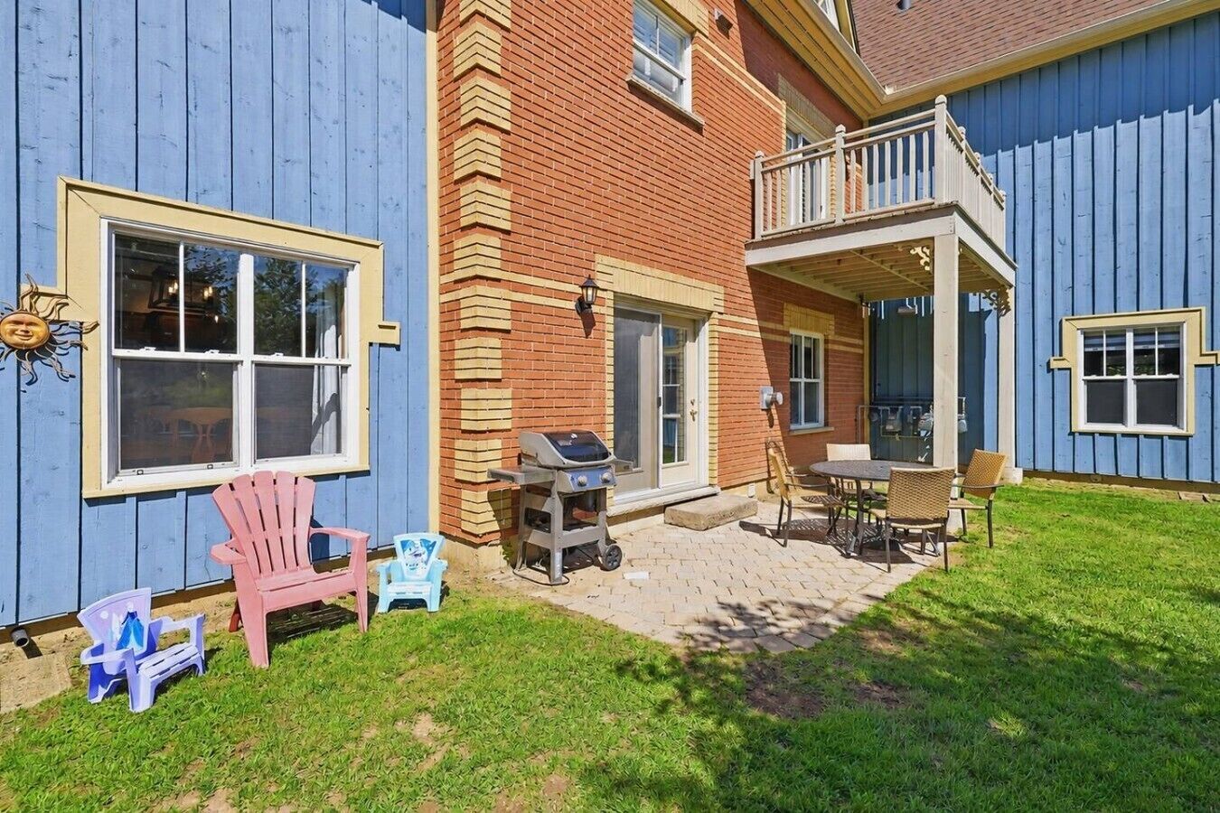 Una propiedad residencial con patio, mobiliario exterior y una parrilla.