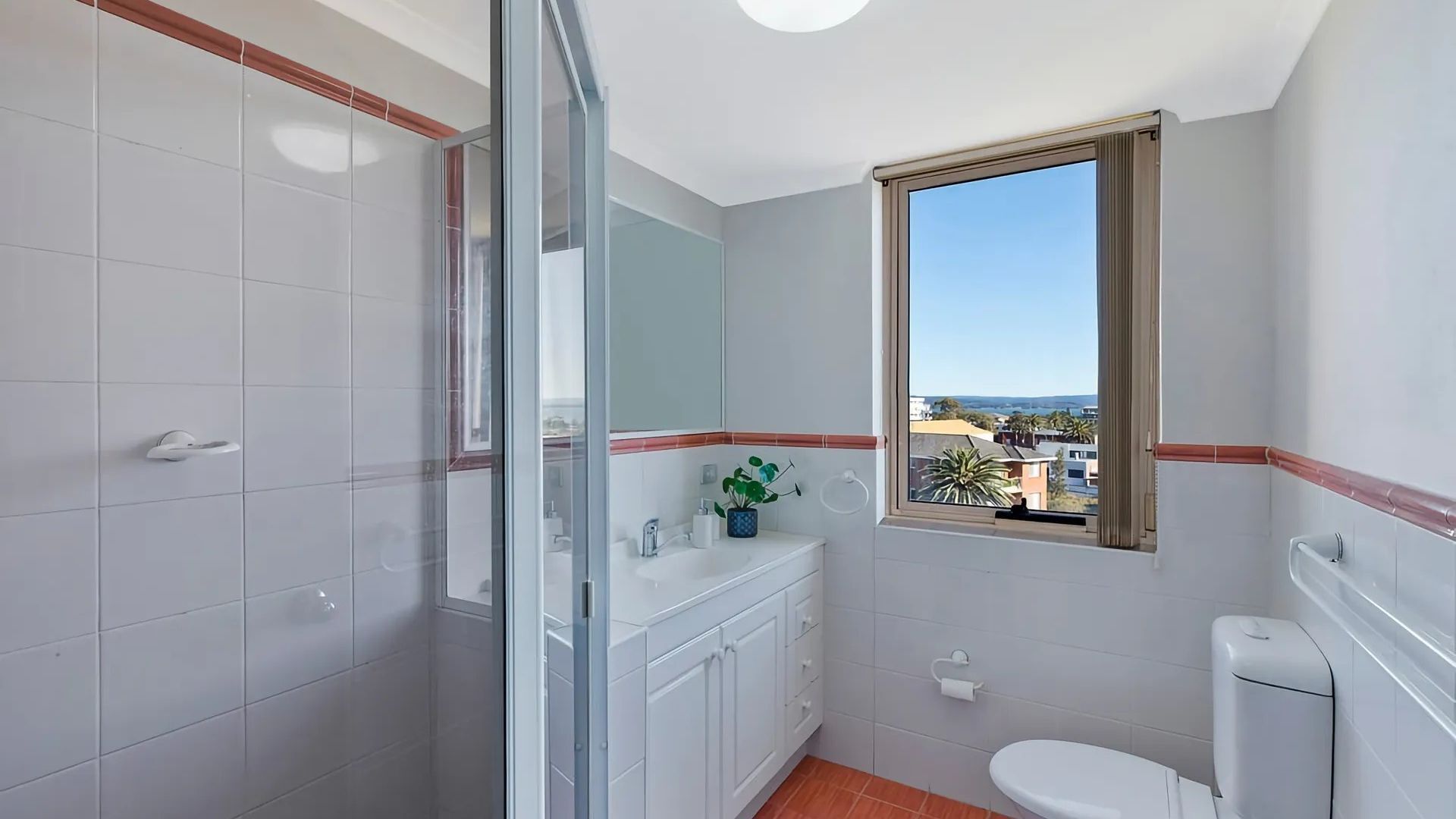 A bathroom with a shower, toilet, and sink.
