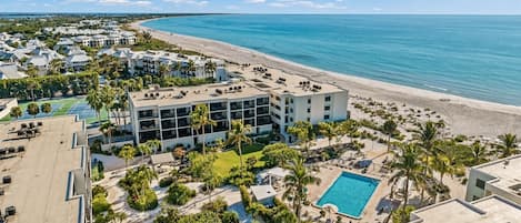 Un resort con piscina, palmeras y vista al mar.