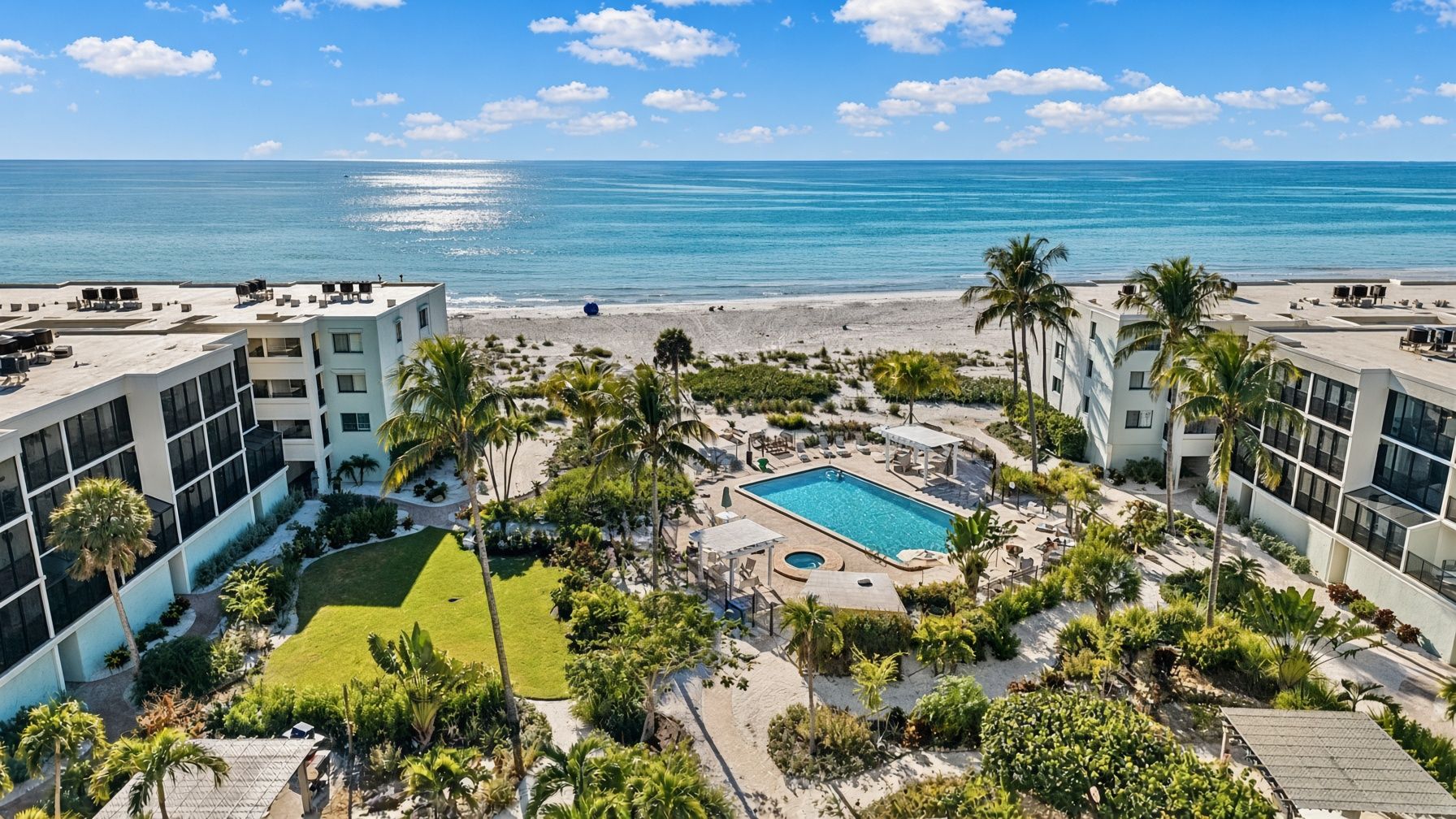 A resort with a swimming pool, palm trees, and a view of the ocean.