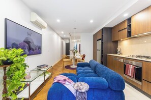 A modern apartment with a living room, dining area, and kitchen. - Toorak Boutique Refined Living by Dining and Fashion (South Yarra)