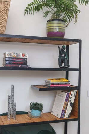 A bookshelf with books and a small figurine.