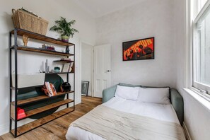 A bedroom with a bed, a bookshelf, a framed picture, and a window. - Rosanna Grove Stylish Haven near Cafs and Parklands (Rosanna)