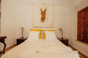 Una camera da letto con un letto, due comodini con lampade, un armadio in legno e un quadro appeso al muro.