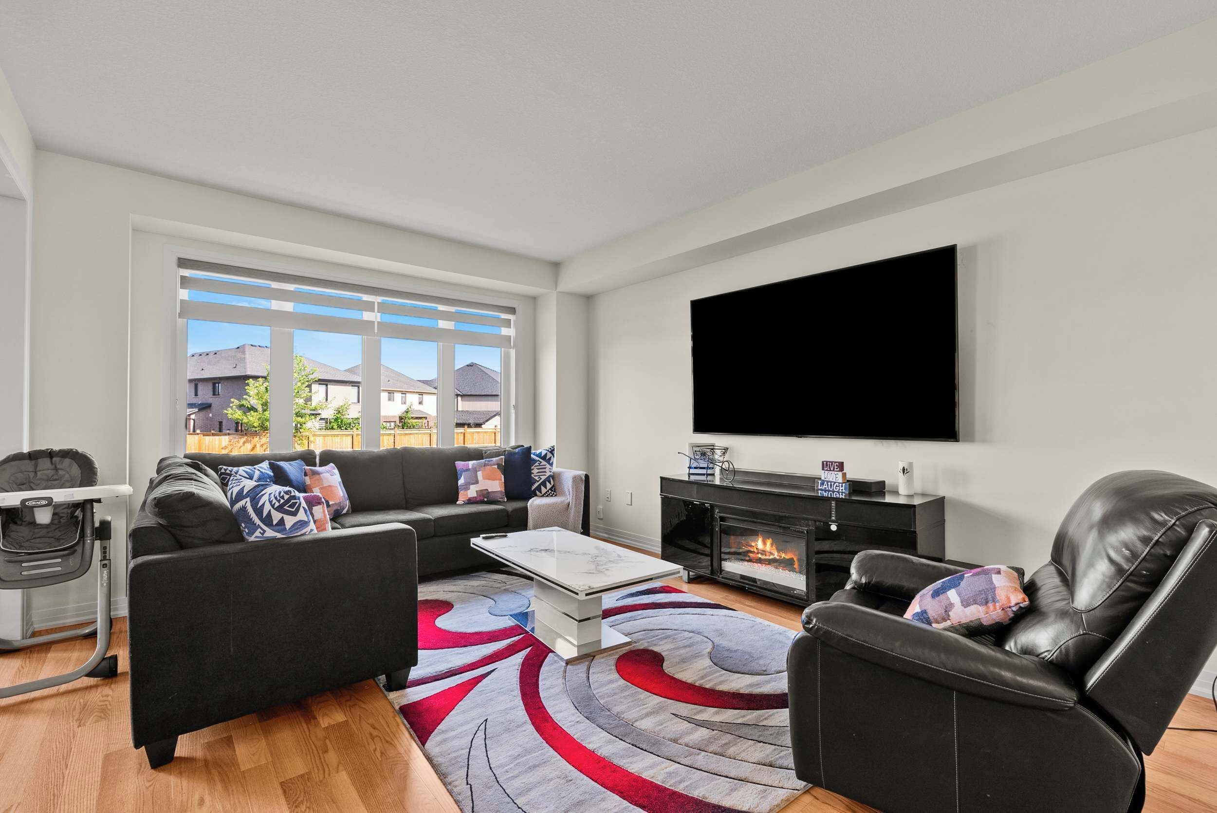 Una sala de estar moderna con sofá, mesa de centro, chimenea y televisor.