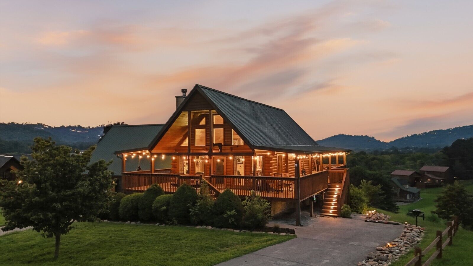 A large wooden cabin with a balcony and a staircase leading to the entrance.
