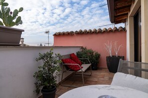 A rooftop terrace with a red chair, potted plants, and a cactus. - Second-floor apartment, ideal for large families and groups of friends (Catania)