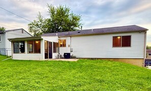 A single-story mobile home with a covered porch, a small attached garage, and a well-maintained lawn. - EV charger modern 4 bedroom, 3 Bathroom house in great neighborhood Cedar Rapids (Cedar Rapids)