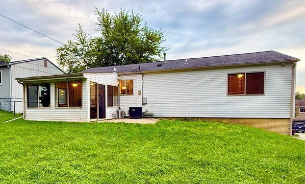 A single-story mobile home with a covered porch, a small attached garage, and a well-maintained lawn.