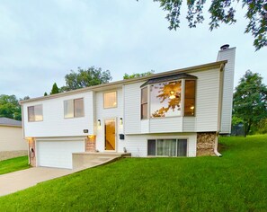A two-story house with a garage, a front porch, and a large window. - EV charger modern 4 bedroom, 3 Bathroom house in great neighborhood Cedar Rapids (Cedar Rapids)