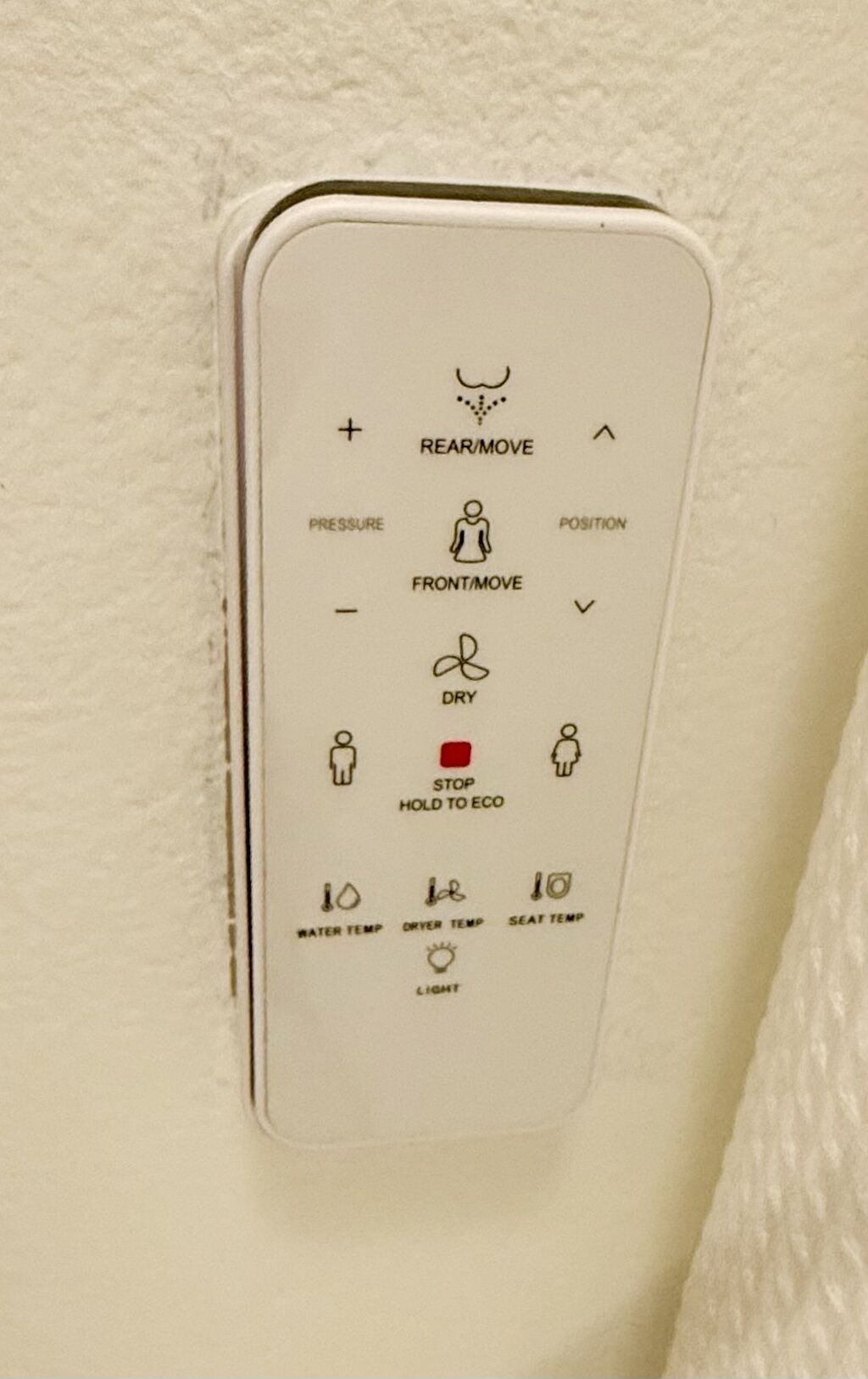 A control panel with symbols for rear/move, front/move, dry, stop hold to eco, water temp, dryer temp, seat temp, and light.