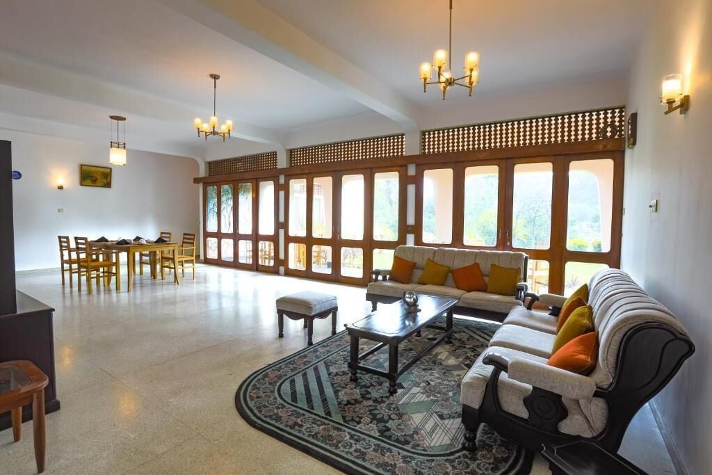 A spacious living area with a sofa, coffee table, and dining set.