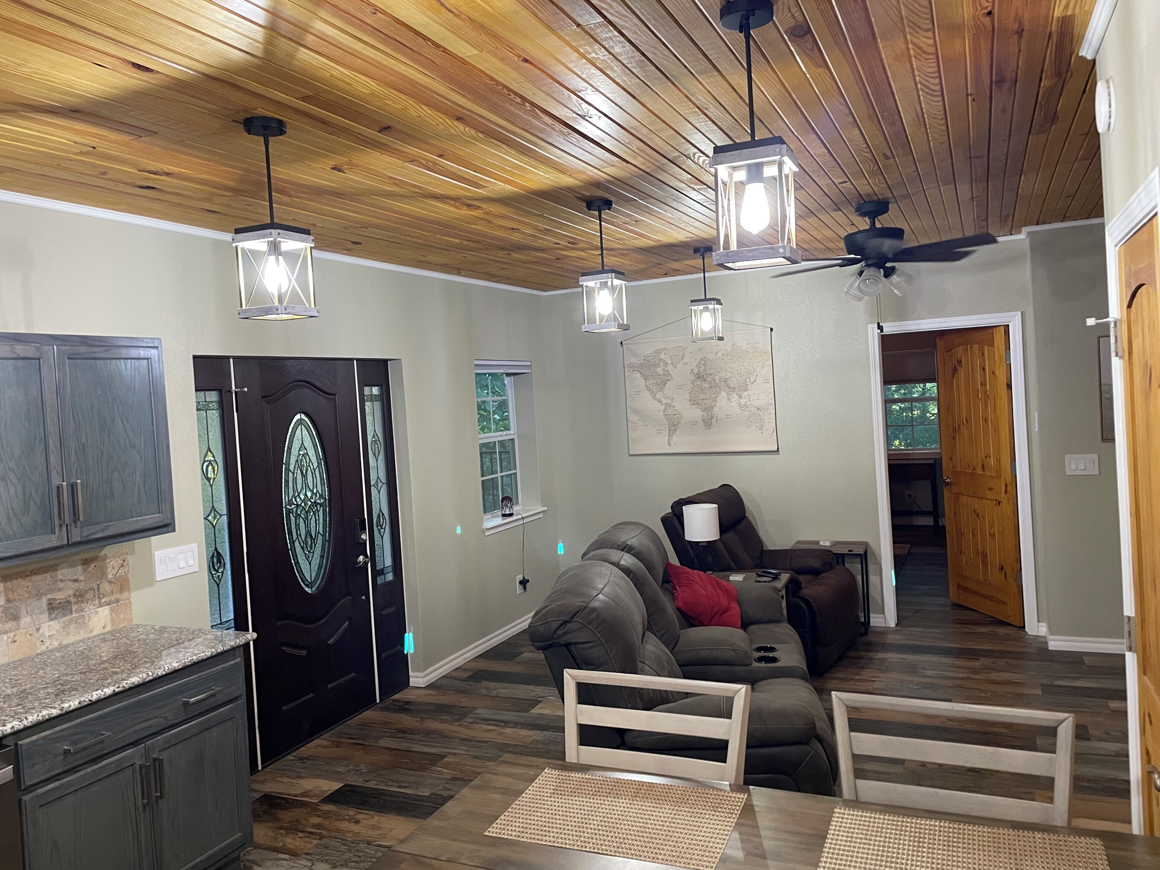 A modern living room with a wooden ceiling, a sofa, a coffee table, and a map on the wall.