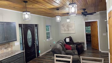 Una sala de estar moderna con techo de madera, un sofá, una mesa de centro y un mapa en la pared.
