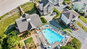 Vista aérea de una zona residencial con una piscina rodeada de casas.