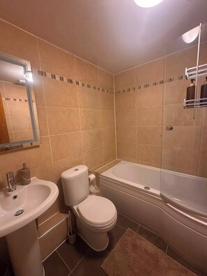 A bathroom with a sink, toilet, and bathtub. - 2-Bed Flat in Shoreditch, Heart of Brick Lane (London)