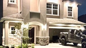 Une maison à deux étages avec un garage et une allée.
