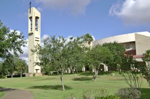 A church with a bell tower and a building with a red roof. - Casa Jerez - Near Padre Island, Church & Hospital (San Juan)