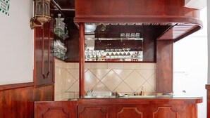 Una zona de bar con mostrador de madera y salpicadero de azulejos.
