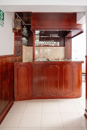 A bar area with a wooden counter and a tiled backsplash. - Rituales Inn Romeritos (Cusco)